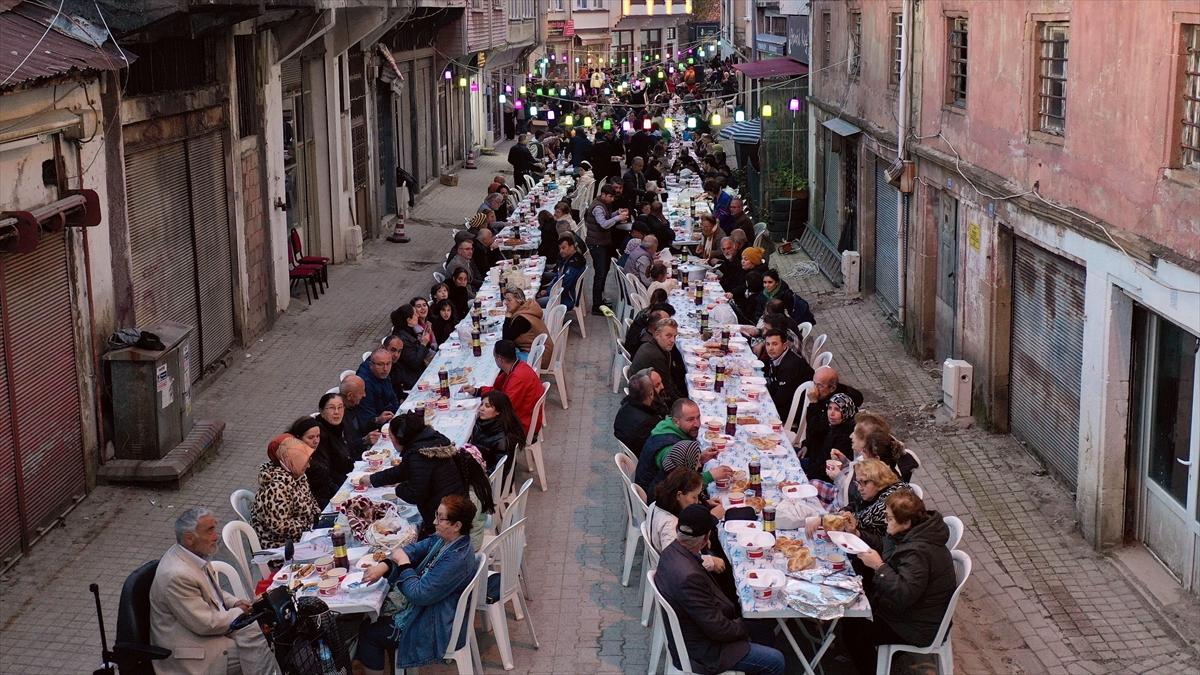 Mahalleli fazladan yaptığı yemekleri sokakta kurulan iftar sofrasında paylaşıyor