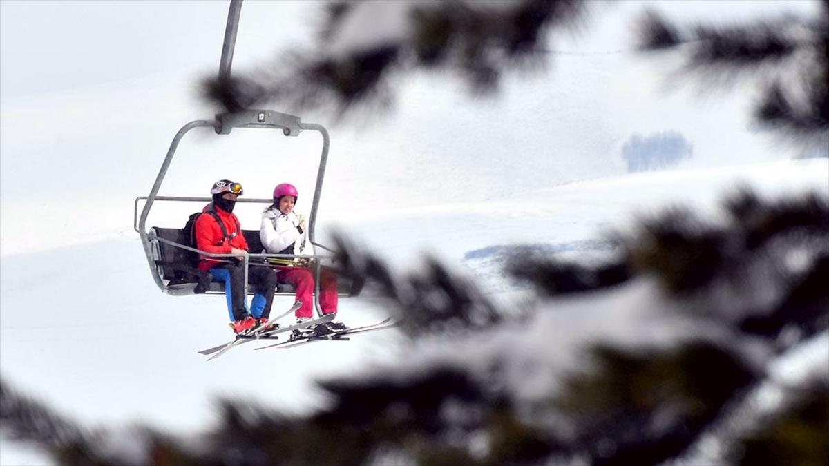 Sarıkamış Kayak Merkezi'nde turistler ilkbaharda kayak yapıyor