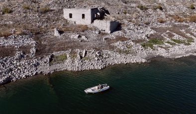 Su altında kalan mahallesinin üzerinde balık avlıyor